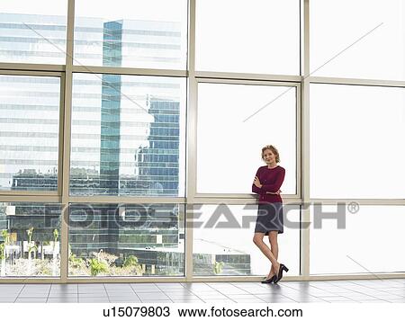 Businesswoman by window in office building, portrait View Large Photo Image Stock Image - Businesswoman by window in office building, portrait. Fotosearch