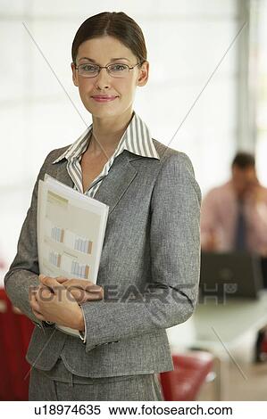 Stock Photography - Businesswoman in Office Holding Reports, portrait. Fotosearch