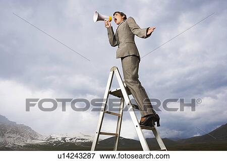 Businesswoman on ladder in mountain field shouting Through Megaphone, low angle view View Large Photo Image Stock Photo - Businesswoman on ladder in mountain field shouting Through Megaphone, low angle view. Fotosearch