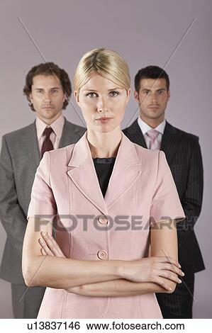 Stock Photograph - Businesswoman standing in front of businessmen, portrait. Fotosearch