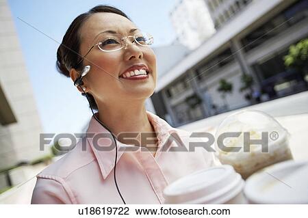 Businesswoman Using Cell Phone with hands free, outdoors View Large Photo Image Stock Image - Businesswoman Using Cell Phone with hands free, outdoors. Fotosearch