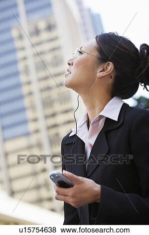 Stock Photo - Businesswoman Using Cell Phone with hands free, outdoors. Fotosearch