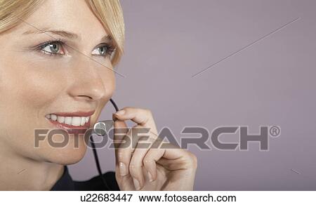 Stock Photo - Businesswoman wearing headset, close-up, portrait. Fotosearch