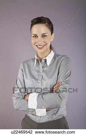 Stock Image - Businesswoman with arms crossed, portrait. Fotosearch