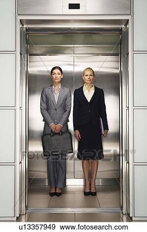Businesswomen Side by Side in Elevator, portrait, front view View Large Photo Image Stock Photo - Businesswomen Side by Side in Elevator, portrait, front view. Fotosearch