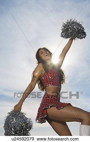 Cheerleader doing routine with pom poms View Large Photo Image Stock Photo - Cheerleader doing routine with pom poms. Fotosearch