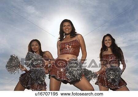 Cheerleaders doing routine with pom poms View Large Photo Image Stock Photography - Cheerleaders doing routine with pom poms. Fotosearch