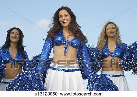 Stock Image - Cheerleaders in costume with pom poms. Fotosearch