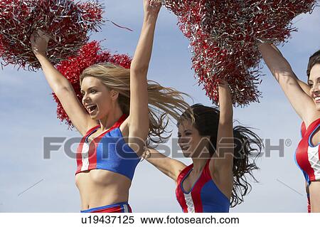 Cheerleaders running holding pom poms in air View Large Photo Image Stock Photography - Cheerleaders running holding pom poms in air. Fotosearch