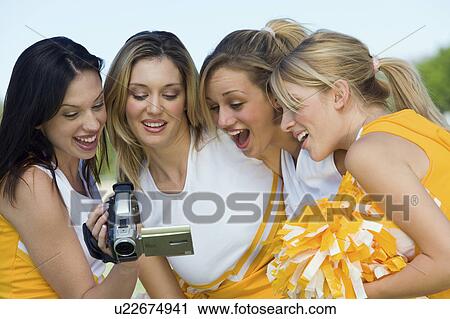 Cheerleaders watching video on video camera View Large Photo Image Stock Image - Cheerleaders watching video on video camera. Fotosearch