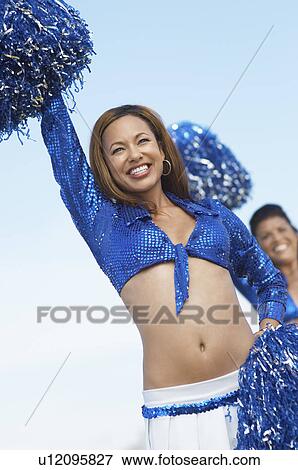 Stock Photo - Cheerleaders with pom poms raised. Fotosearch