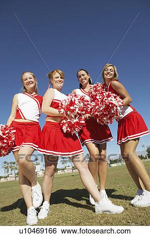 Cheerleaders with Pom-poms standing on football field, low angle view, portrait, (portrait), (low angle view) View Large Photo Image Stock Photograph - Cheerleaders with Pom-poms standing on football field, low angle view, portrait, (portrait), (low angle view). Fotosearch