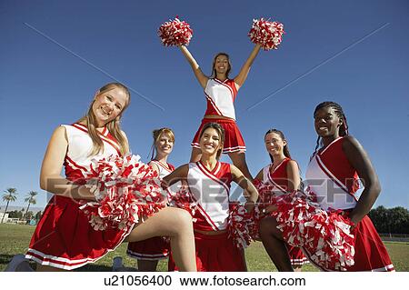 Stock Image - Cheerleading squad in formation on field, portrait, (portrait). Fotosearch