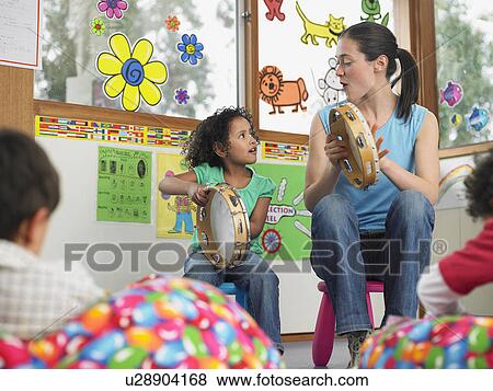 Children with teacher playing music in classroom View Large Photo Image Stock Photo - Children with teacher playing music in classroom. Fotosearch