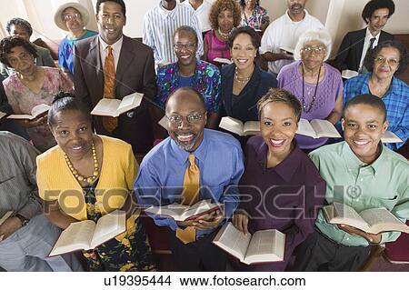 Picture - Church congregation sitting on church pews with Bible, portrait, high angle view. Fotosearch