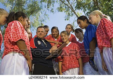 Picture - Coach with girls' soccer team (13-17). Fotosearch
