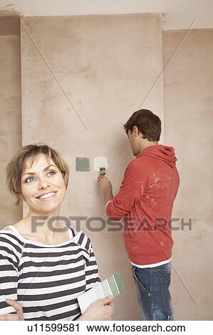 Couple choosing paint colours in unrenovated room View Large Photo Image Stock Image - Couple choosing paint colours in unrenovated room. Fotosearch