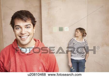 Couple choosing paint colours in unrenovated room View Large Photo Image Stock Photo - Couple choosing paint colours in unrenovated room. Fotosearch