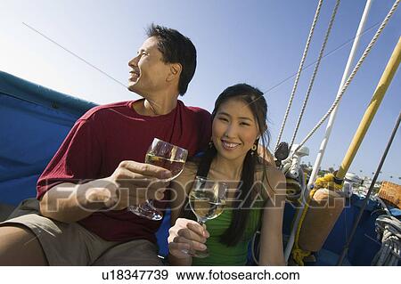 Couple dinking white wine on boat View Large Photo Image Stock Photo - Couple dinking white wine on boat. Fotosearch