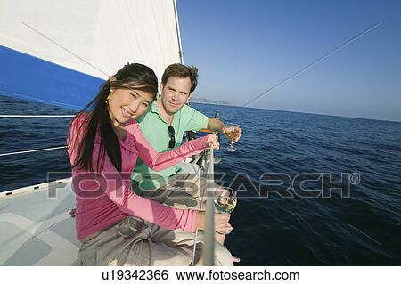 Couple dinking white wine on sailboat, (portrait) View Large Photo Image Stock Photograph - Couple dinking white wine on sailboat, (portrait). Fotosearch