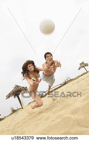 Couple Diving for Volleyball on Beach, tilt view View Large Photo Image Stock Photo - Couple Diving for Volleyball on Beach, tilt view. Fotosearch
