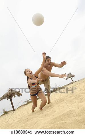 Couple Diving for Volleyball on Beach, tilt view View Large Photo Image Stock Photography - Couple Diving for Volleyball on Beach, tilt view. Fotosearch