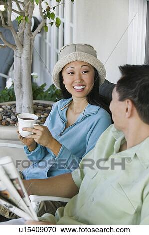 Couple drinking coffee and reading newspaper, outdoors View Large Photo Image Stock Image - Couple drinking coffee and reading newspaper, outdoors. Fotosearch