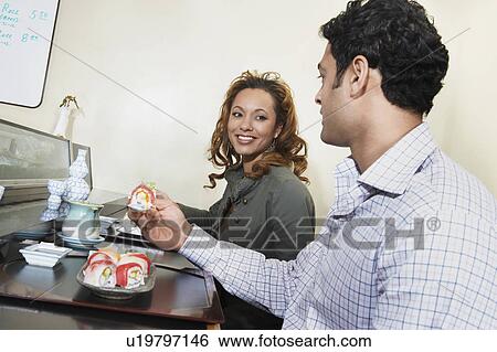Stock Photograph - Couple eating sushi in restaurant. Fotosearch