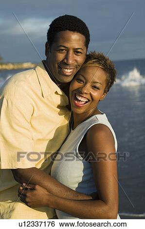 Couple embracing at ocean, (portrait) View Large Photo Image Stock Photograph - Couple embracing at ocean, (portrait). Fotosearch