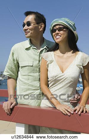 Picture - Couple embracing by outdoor railing. Fotosearch