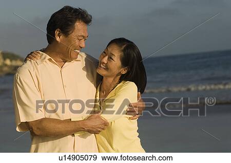 Stock Photo - Couple embracing on beach. Fotosearch