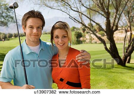 Couple embracing on golf course, (portrait) View Large Photo Image Stock Image - Couple embracing on golf course, (portrait). Fotosearch