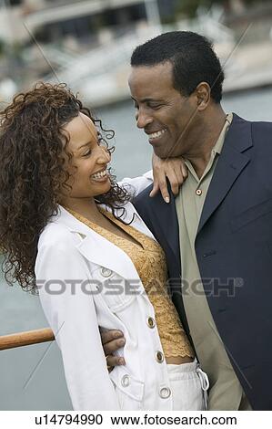 Stock Image - Couple embracing on yacht. Fotosearch