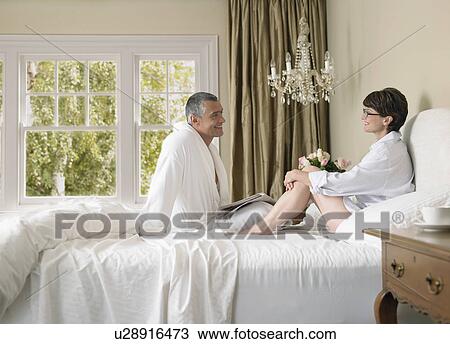 Couple enjoying lazy morning in bed View Large Photo Image Stock Image - Couple enjoying lazy morning in bed. Fotosearch
