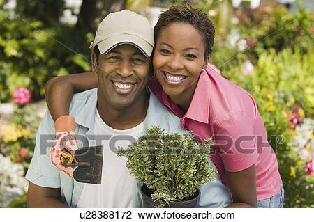Stock Image - Couple gardening, (portrait). Fotosearch