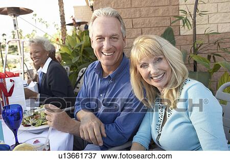 Couple Having Lunch outdoors with friends View Large Photo Image Stock Photo - Couple Having Lunch outdoors with friends. Fotosearch