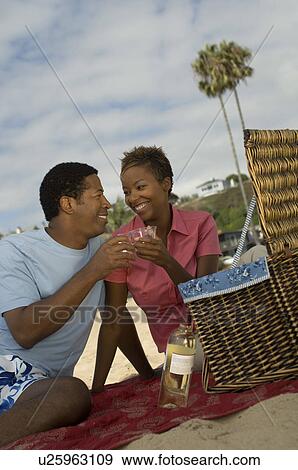 Stock Photo - Couple having picnic at beach. Fotosearch