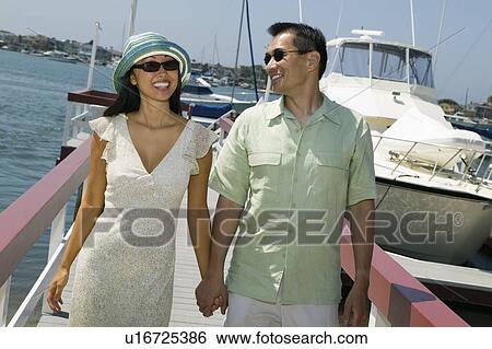 Stock Photograph - Couple holding hands on docks. Fotosearch