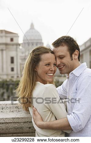 Stock Photo - Couple hugging on bridge in Rom, Italy, side view. Fotosearch
