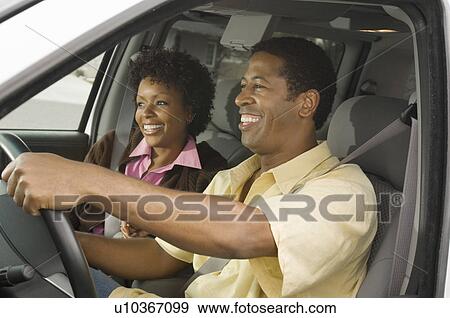 Couple in car, man driving, close-up View Large Photo Image Stock Photo - Couple in car, man driving, close-up. Fotosearch