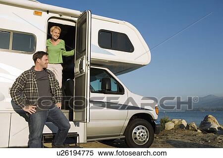 Stock Photography - Couple in RV at lakeshore. Fotosearch