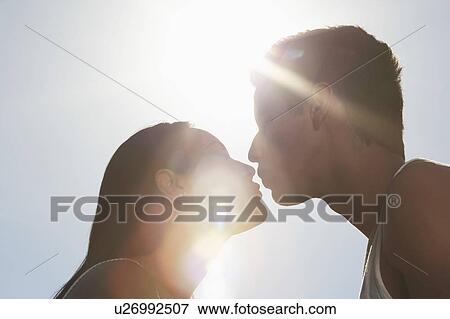 Couple kissing outdoors in sunlight, profile View Large Photo Image Stock Photo - Couple kissing outdoors in sunlight, profile. Fotosearch