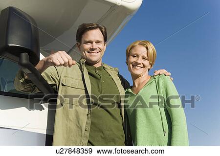 Couple leaning on RV, low angle view View Large Photo Image Stock Photo - Couple leaning on RV, low angle view. Fotosearch