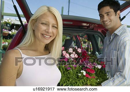 Stock Photo - Couple Loading Plants Into Minivan, portrait. Fotosearch