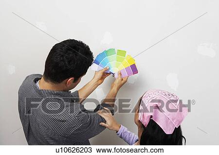 Couple looking at paint samples near interior wall, back view, elevated view View Large Photo Image Stock Image - Couple looking at paint samples near interior wall, back view, elevated view. Fotosearch