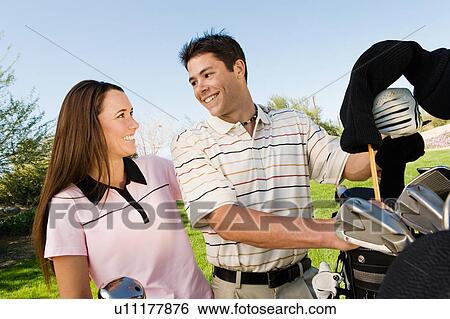 Couple of golfers chatting on golf course View Large Photo Image Stock Photograph - Couple of golfers chatting on golf course. Fotosearch
