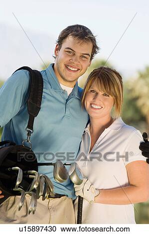Couple of golfers embracing on golf course, (portrait) View Large Photo Image Stock Image - Couple of golfers embracing on golf course, (portrait). Fotosearch