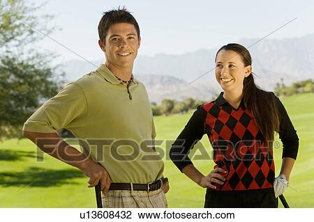 Couple of golfers standing together on golf course, (portrait) View Large Photo Image Stock Image - Couple of golfers standing together on golf course, (portrait). Fotosearch