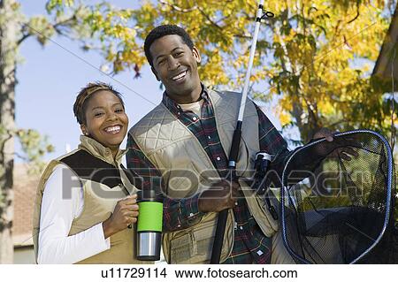 Couple on fishing trip, smiling, (portrait) View Large Photo Image Picture - Couple on fishing trip, smiling, (portrait). Fotosearch