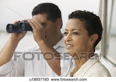 Couple on yacht, man looking through binoculars View Large Photo Image Stock Image - Couple on yacht, man looking through binoculars. Fotosearch